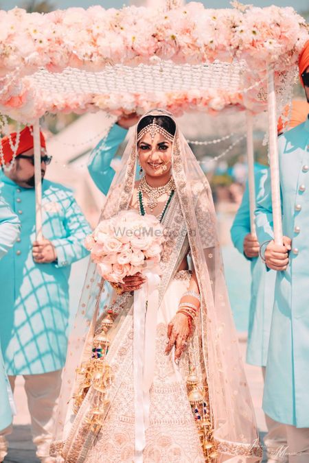 Bride under peach phoolon ka chadar with bouquet 