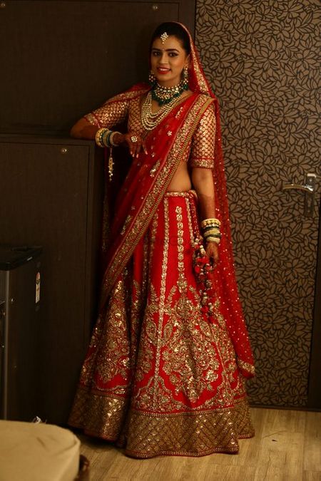 Photo of Red classic bridal lehenga in raw silk with large motif of intrictae embroidery