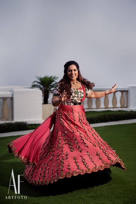 Photo of Twirling bride in bright coral lehenga
