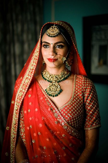 Photo of Contrasting jewellery with red lehenga and minimal look