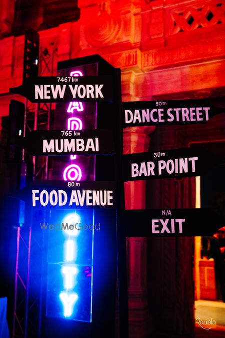 Photo of Fun entry decor with signages to the bar and dance floor for sangeet