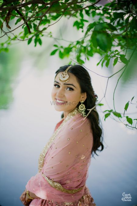 A bride in a light pink outfit for her mehndi