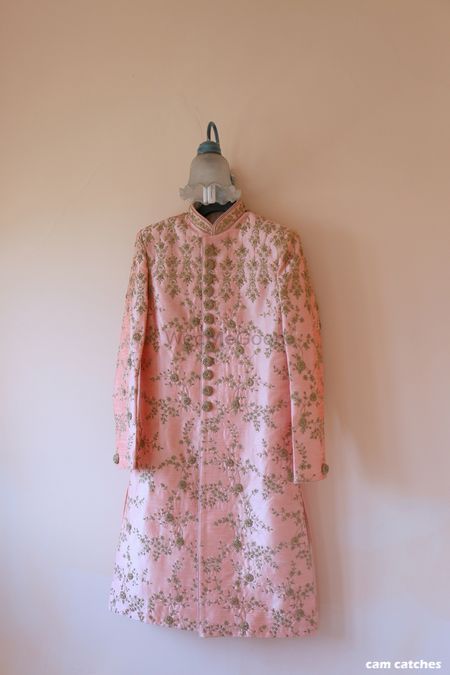 Light pink sherwani on a hanger with embroidery