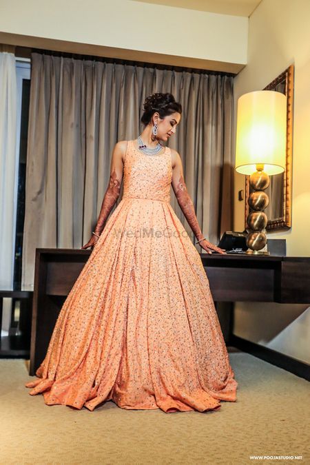 Peach floor length sleeveless voluminous full flare sparkly gown with sequin work