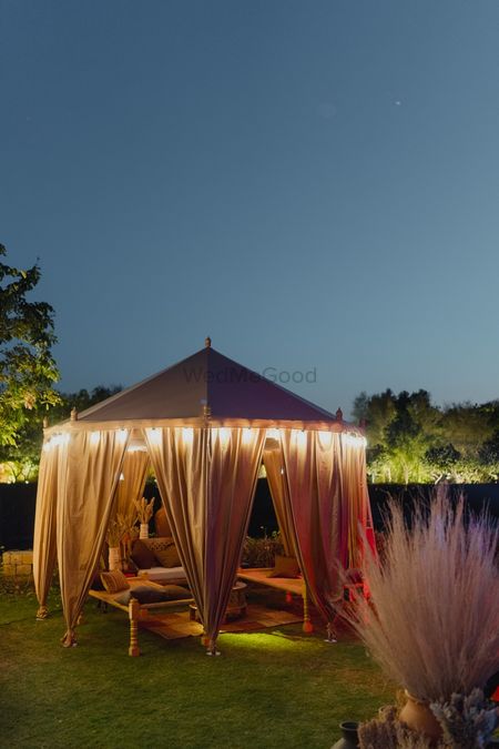 Gorgeous tent decor seating idea with lights in the outdoors. 