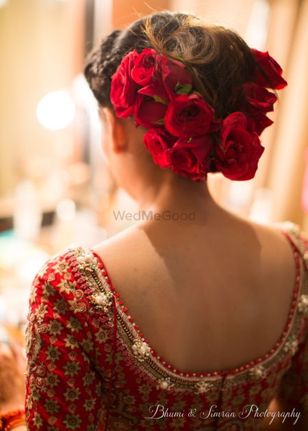 A bride getting her hair done with roses on wedding day 