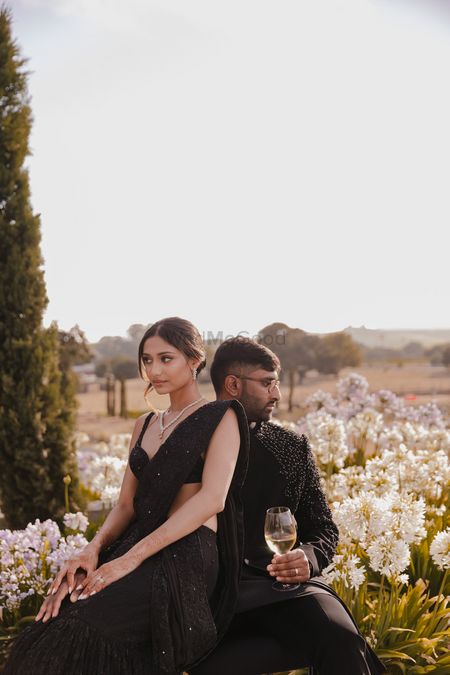 Gorgeous couple portrait with the couple in co-ordinated black outfits in a field of flowers
