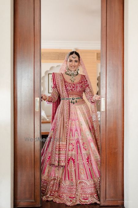 Photo of Stunning pink and gold lehenga with an emerald studded belt and polki and emerald jewellery