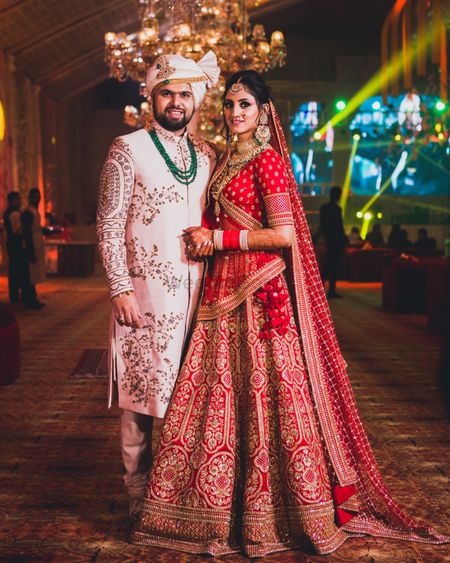 Photo of Contrasting bride and groom outfits in red and white