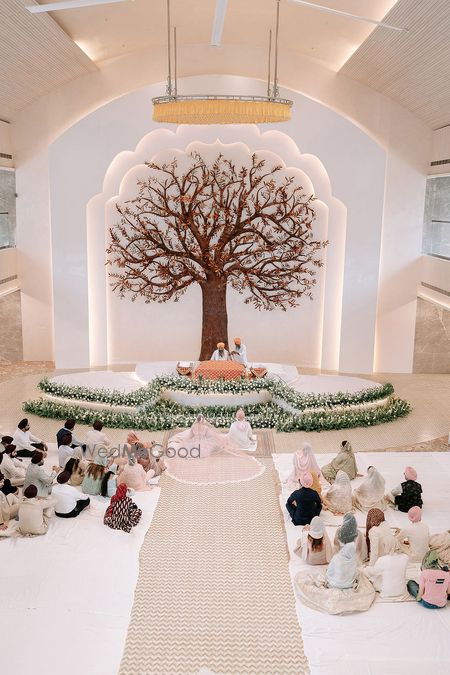 Photo of Super stunning tree of life mandap and wedding stage with floral decor
