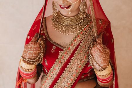 A bride in red outfit and gold jewellery