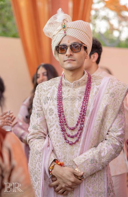 Heavy embroidered sherwani with ruby necklace for groom.