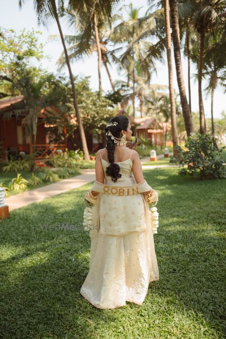 Photo of Gorgeous beige sharara for the haldi with personalised dupatta with the groom's name written