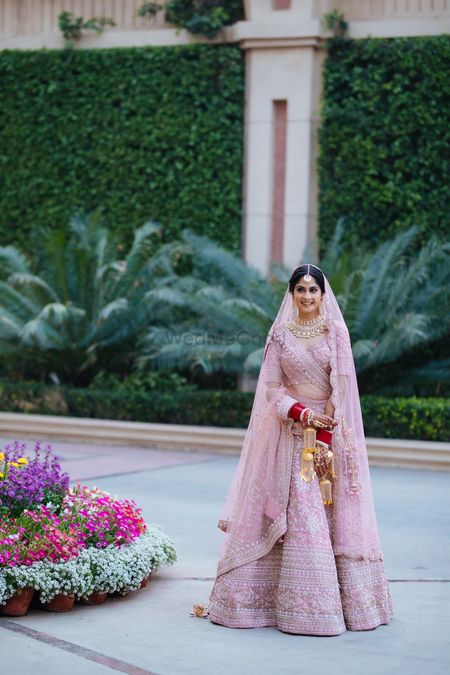 Bride wearing a pastel pink lehenga.