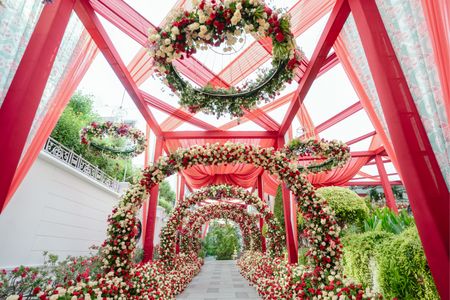 White, red and green themed floral entrance decor with floral chandeliers.