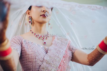 Photo of A bride using her dupatta as veil on her wedding day