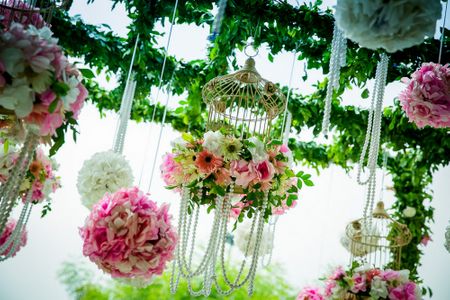 Pink and green birdcages with pearls and floral balls