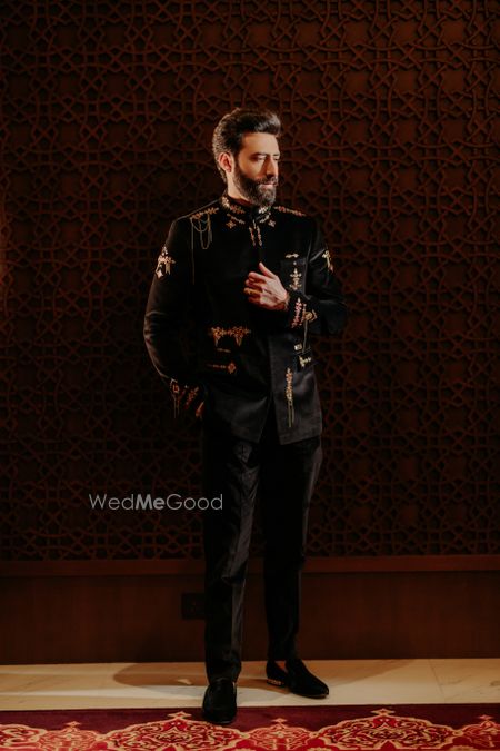 Photo of Super stylish all black and gold groom outfit for the sangeet day