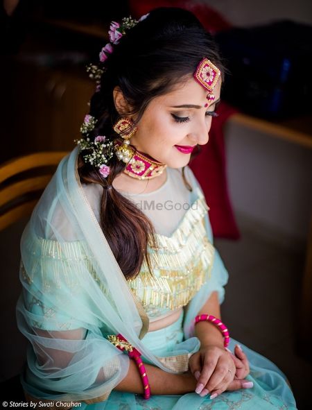 Bride with unique mehendi jewellery and flowers in short braid 