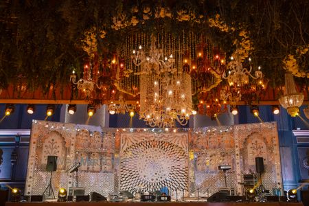 Grand decor for the sangeet stage with chandelier and florals