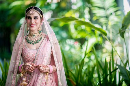 Bridal portrait with the bride in a pink Anita Dongre lehenga 