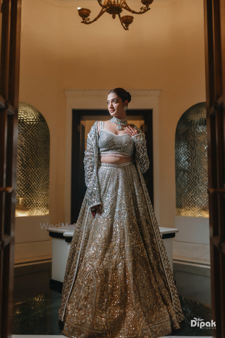 Statement shimmer lehenga in gold and silver with a floor length jacket and jade jewellery for the sangeet night