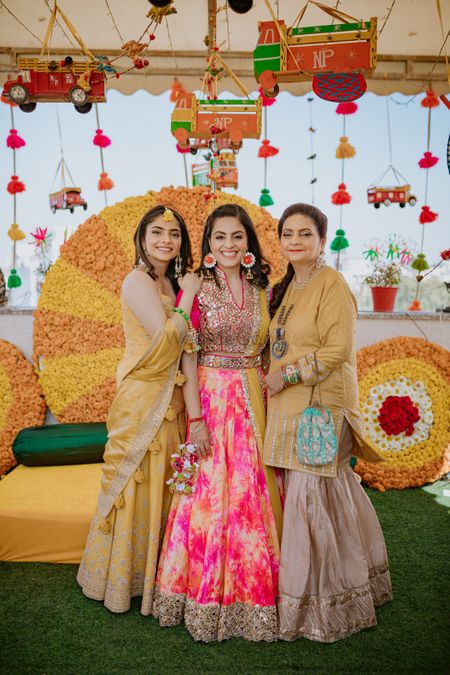 Bride posing with her mother and sister on her Haldi.