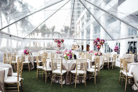 Photo of White and gold table setting with transparent tent