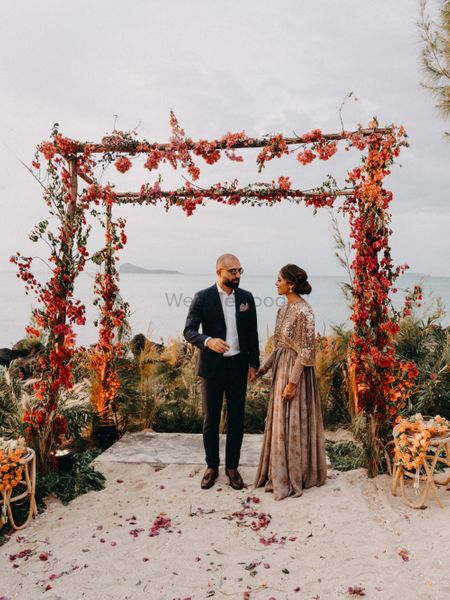 Photo of A couple shot candidly at their minimalist floral mandap