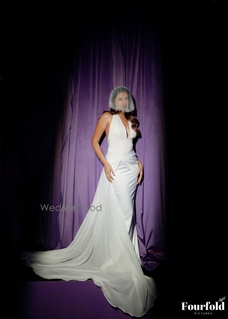 All white gown with a halter and plunging neckline and delicate veil 