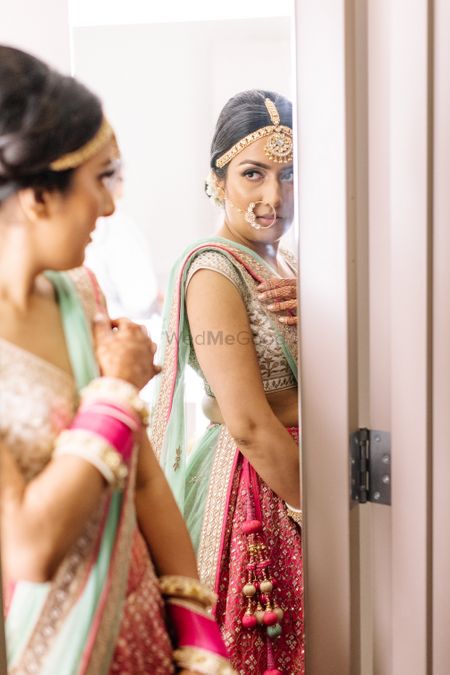 Bride getting ready shot while looking into mirror