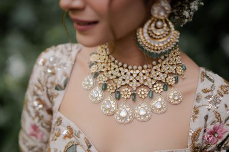 A stunning shot of the bridal jewellery set in polki and kundan work with emerald and diamonds