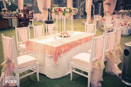Photo of White and peach reception table seating with florals