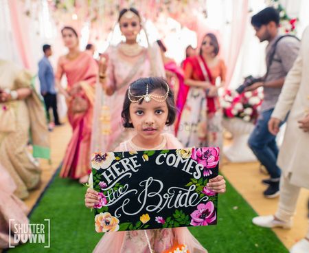 Cute bridal entry with niece holding board 