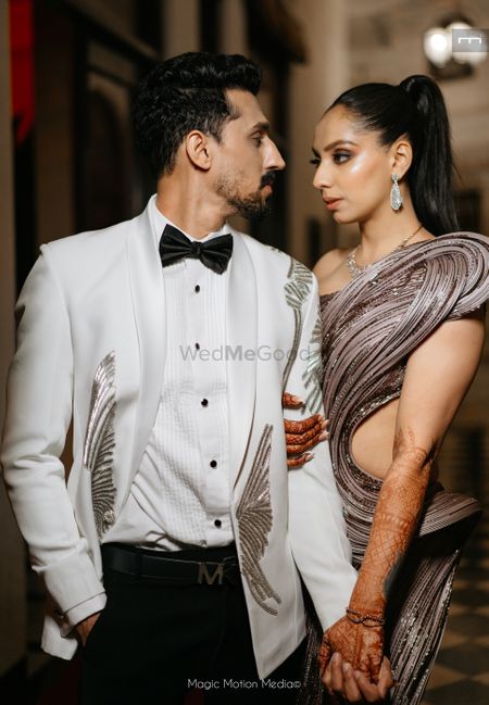 Fun shot of the couple with the groom in a white tuxedo and bride in a modern shimmery gown