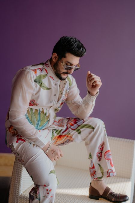 Stylish groom shot with the groom in a floral printed jacket set on his haldi