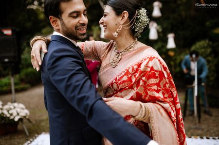 bridal bun with flowers and bride in red sabyasachi saree