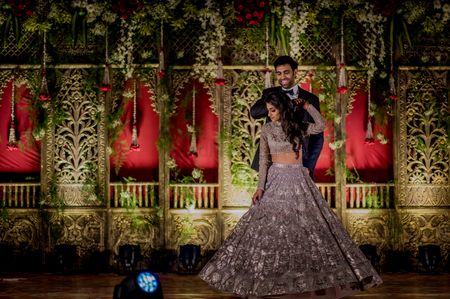 A couple in coordinated outfits dance at their sangeet ceremony