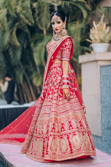 Photo of red sabyasachi bridal lehenga with matching chuda