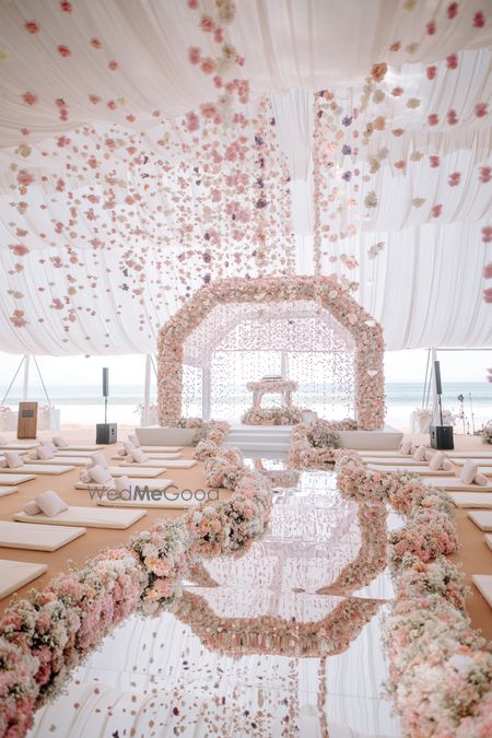 Gorgeous floral mandap in pink and white with a mirror aisle with hanging floral decor 