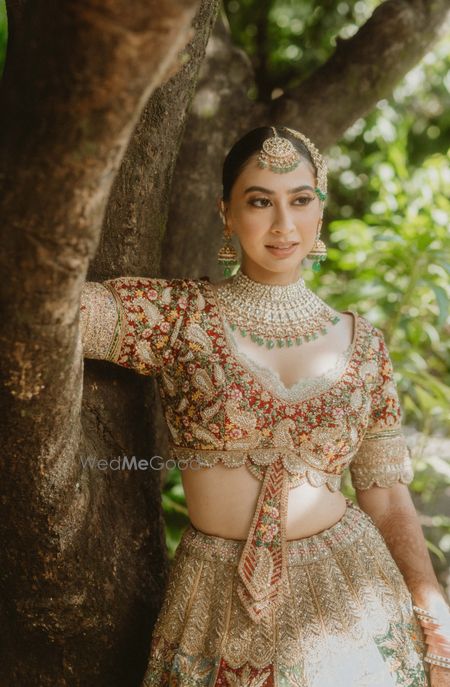 Photo of Heavy embroidered bridal blouse in red, green and gold with tie-detailing