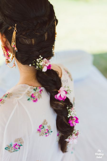 Photo of pretty mehendi braided hairstyle with flowers and babys breath