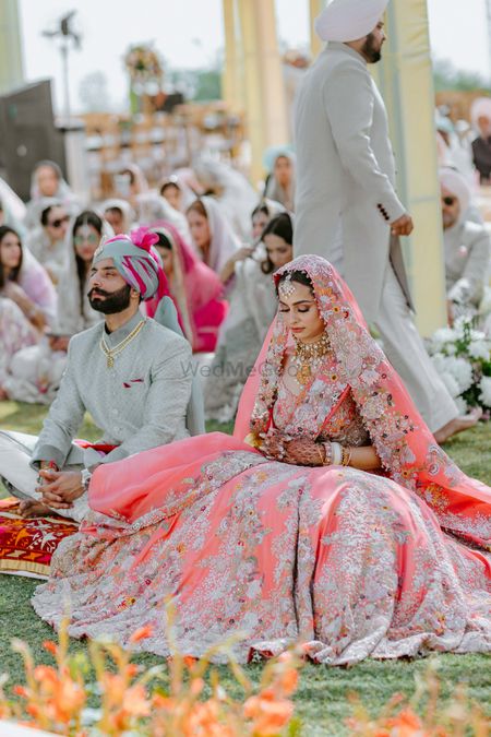 Bridal portrait in coral lehenga on Anand Karaj