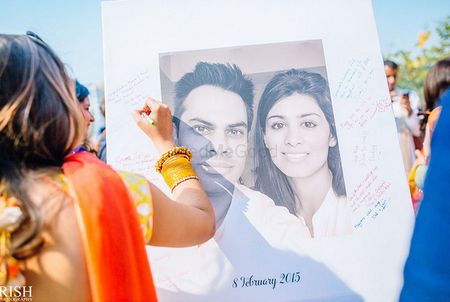 Guests sign and leave messages on a guest book which is a printed photo of the bride and groom