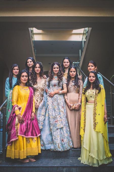 A bride poses with her bridesmaids in blue lehenga