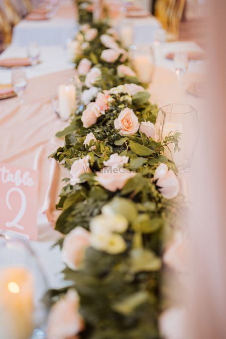 Photo of floral table runner with leaves and roses