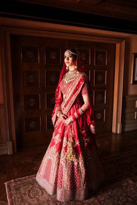 Bride in a red and gold classic sabyasachi lehenga for her wedding day