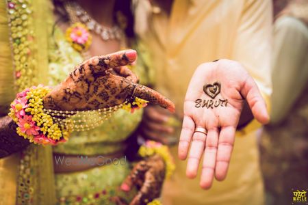 Photo of sisters and friends of the bride pose as the bride gets her mehendi  done