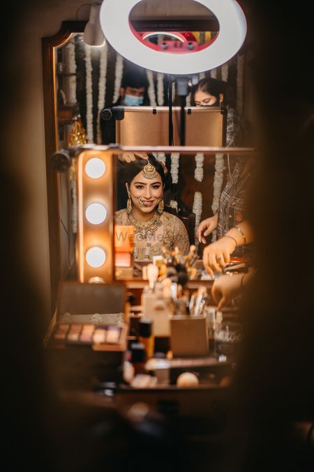 Bride looks at herself in mirror while getting ready 