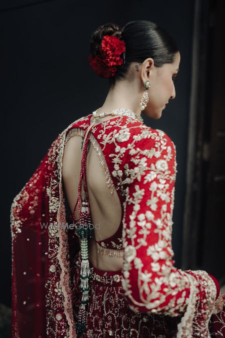 Lovely all red cutout style backless blouse with full sleeves and gold embroidery for the wedding lehenga